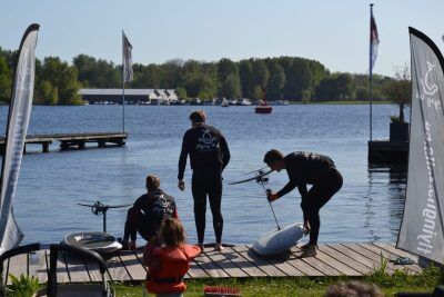 groepsuitje efoilen Flying fish team met meertje op de achtergrond met drie eFoils tijdens een groepsuitje